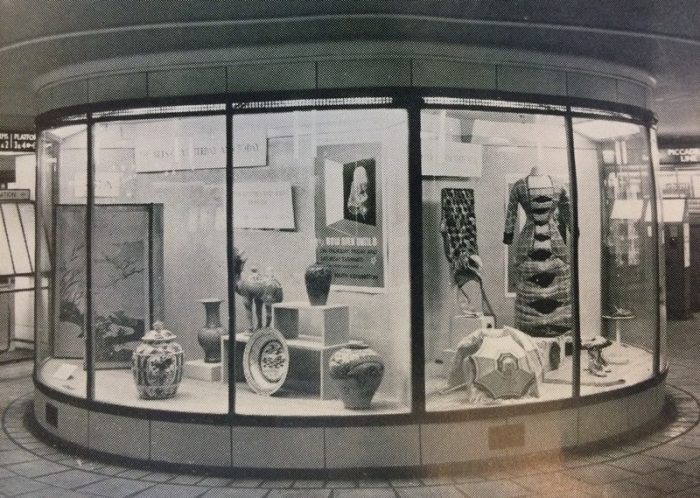 A museum display case in the rotunda in the ticket hall at Leicester Square tube station. Two cases show museum objects and signs